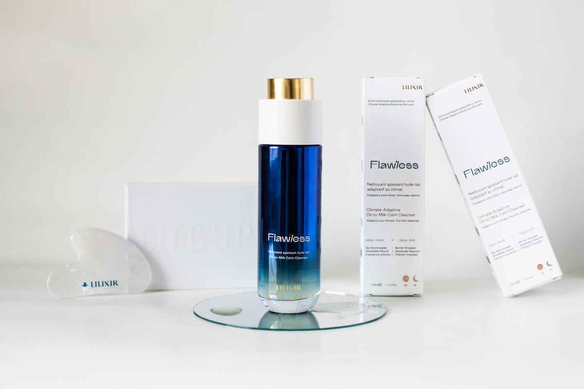 LILIXIR Flawless skincare set featuring a blue gradient bottle with a gold cap, two white product boxes, and a white crystal gua Sha arranged on a white surface with a glass coaster.
