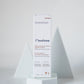 A white rectangular skincare box labeled 'LILIXIR Flawless' stands upright on a white pedestal against a light gray studio background with geometric white supports.