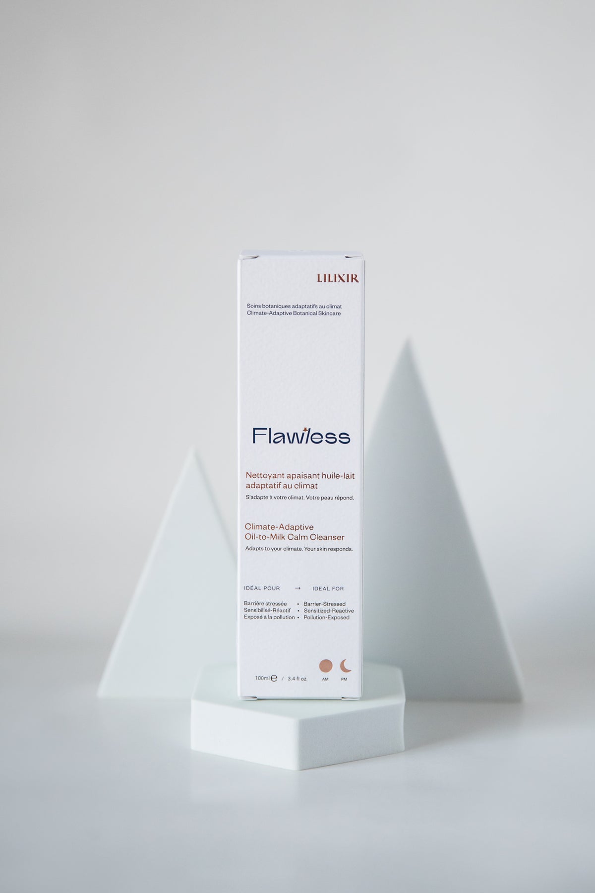 A white rectangular skincare box labeled 'LILIXIR Flawless' stands upright on a white pedestal against a light gray studio background with geometric white supports.