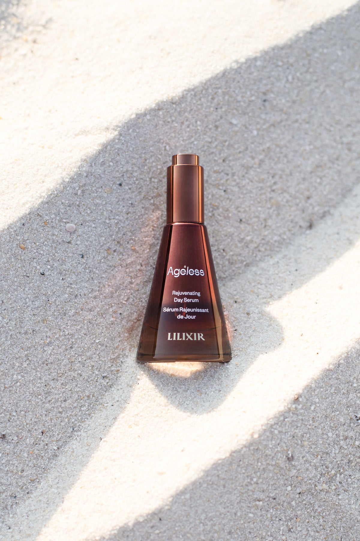 LILIXIR skincare serum bottle on a textured surface with sunlight casting shadows