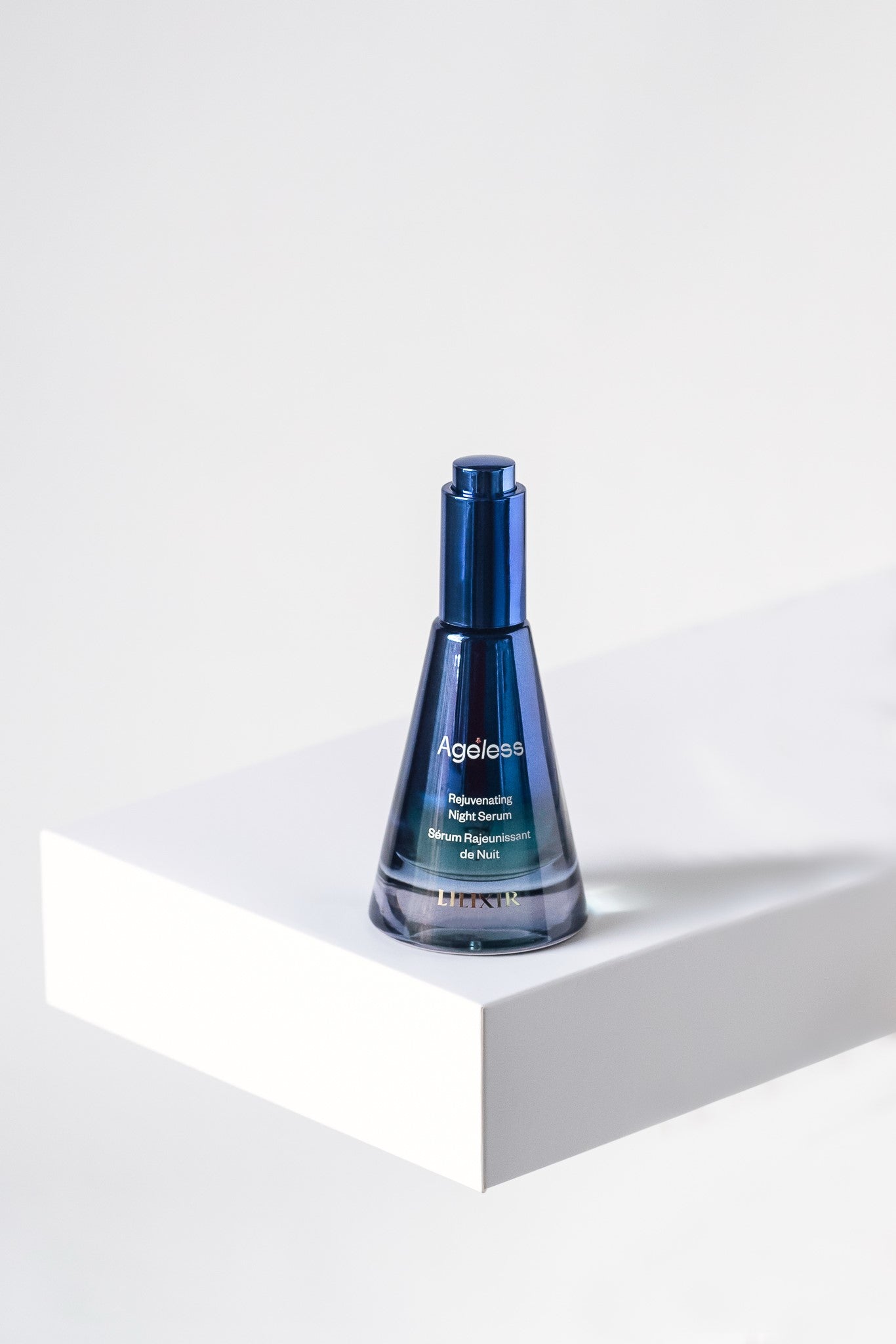 Blue bottle with LILIXIR Ageless branding on a white surface and background