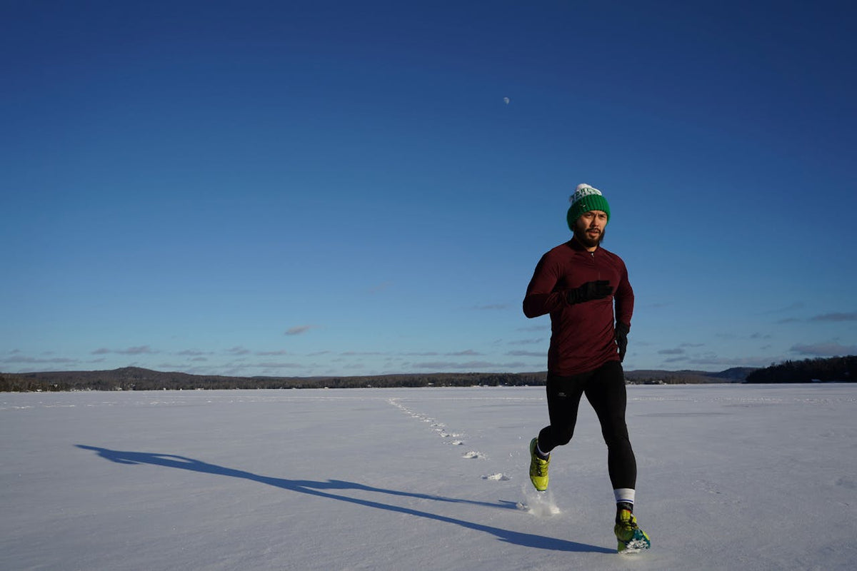 Person running on a frozen lake with a clear blue sky