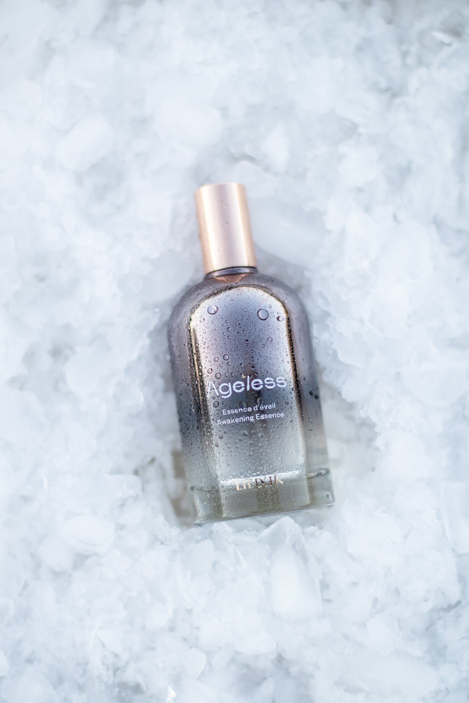 Bottle of 'LILIXIR Ageless Awakening Essence ' on a textured white background