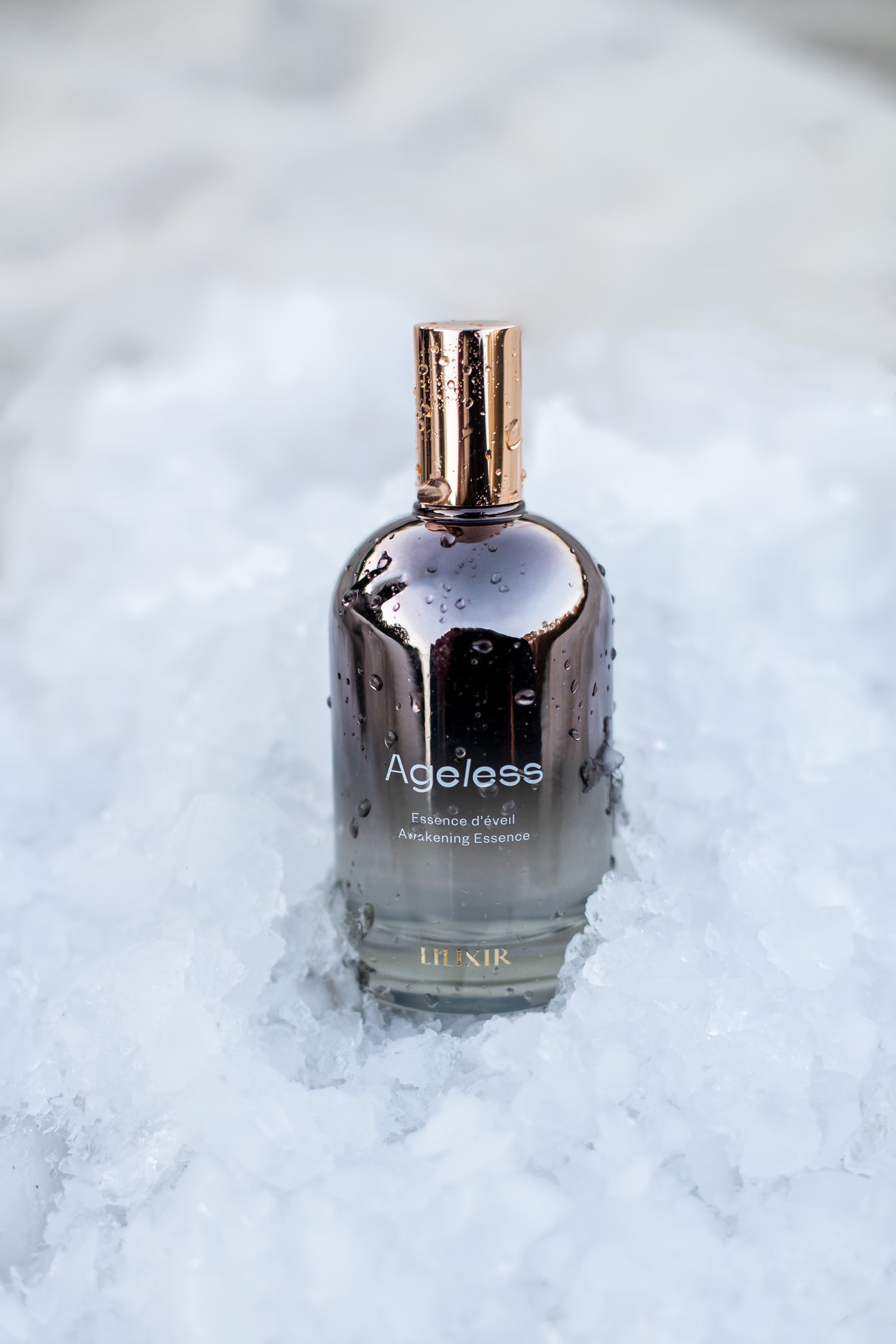 Bottle LILIXIR Ageless Awakening Essence on a textured white background