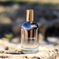 Bottle of Ageless Awakening Essence on a rock with a blurred natural background