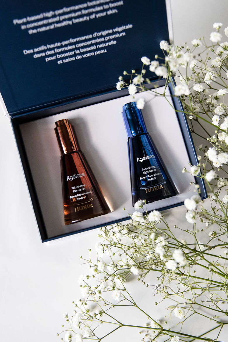 Two lilixir serums skincare bottles in a box with white flowers on a light surface