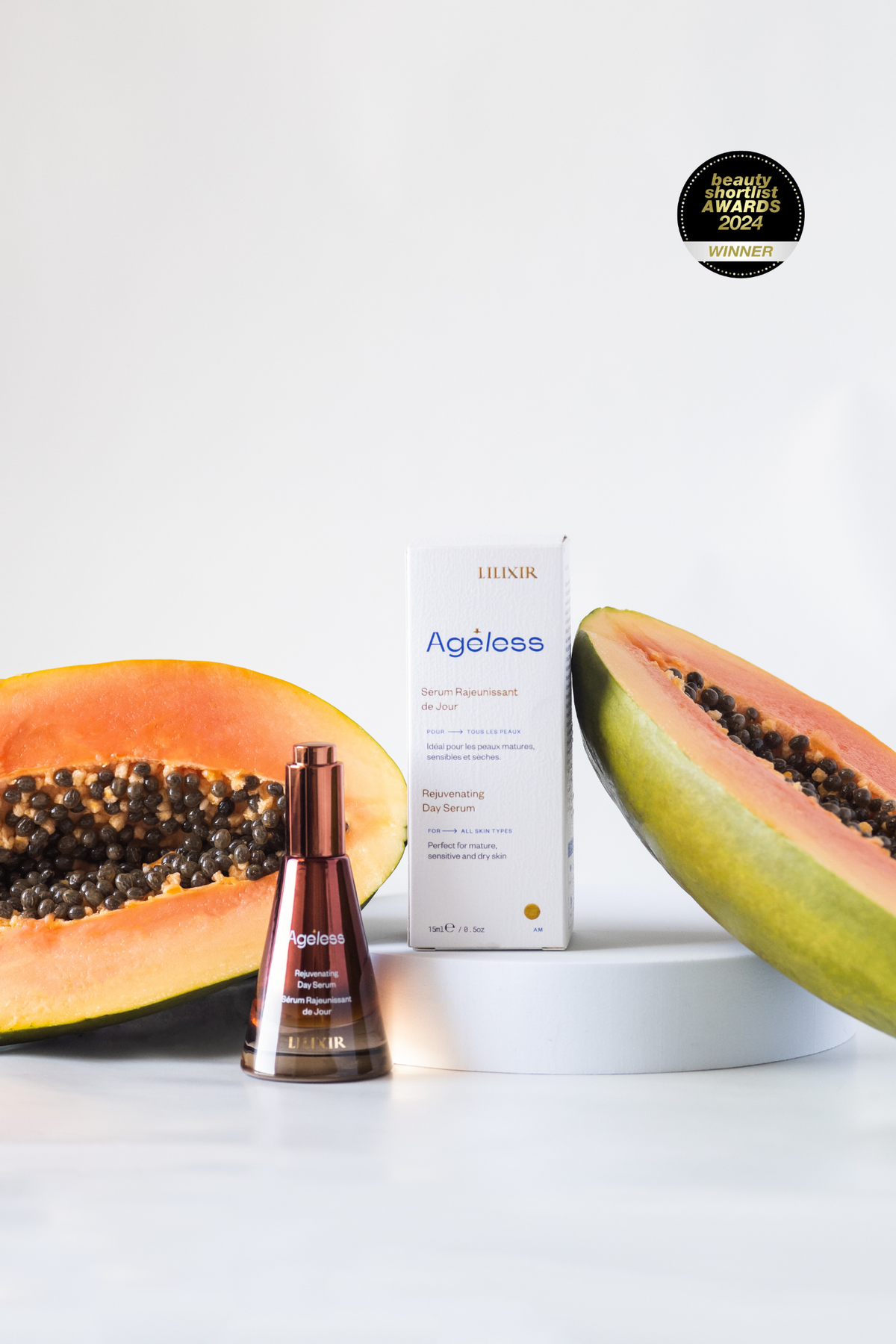 Lilixir ageless rejuvenating day serum, skincare product with a halved papaya on a white background