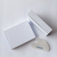 White box with a heart-shaped gua sha product on a white background