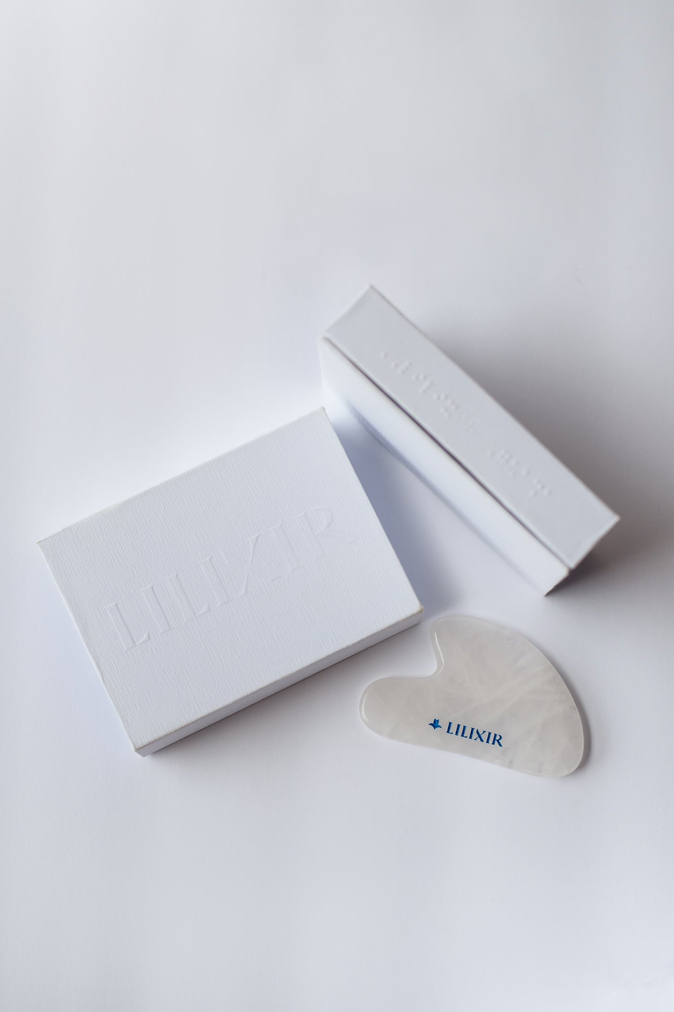 White box with a heart-shaped gua sha product on a white background
